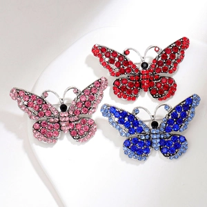 Dettaglio di spille a farfalla con strass colorati e base in lega d'argento lucida
