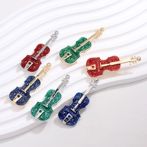 Detailed view of elegant violin brooches with colorful enamel and embossed patterns