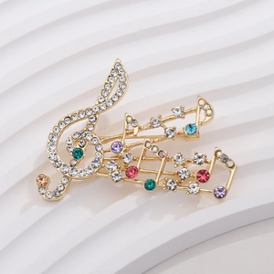Macro detail of the musical note violin brooch with colorful rhinestones on gold plating