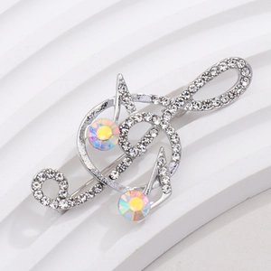 Macro detail of violin musical note brooch with sparkling crystals on white stand