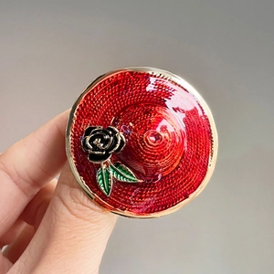 Elegant red straw hat brooch with black rose and green leaves in vintage style