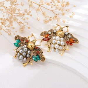 Detailed close-up of bee brooches featuring colorful rhinestones and imitation pearls
