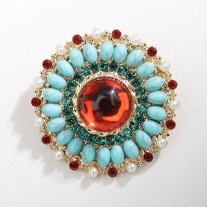 Detailed close-up of retro bohemian brooch with red stones and blue turquoise beads