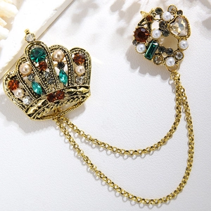 Vintage gold crown brooch with emerald gemstones and pearls connected by metal chains