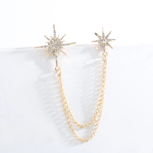 Detail von goldenen Schneeflocken-Broschen mit weißen Zirkonia und eleganten Doppelketten