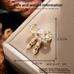 Vintage golden bowknot brooch with sparkling white rhinestones and a central crystal