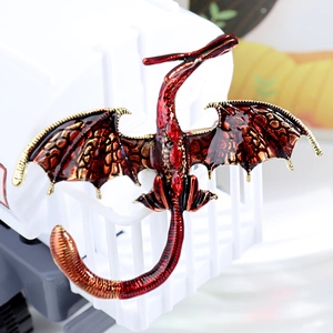 Vintage gold flying dragon brooch with red enamel wings and ruby red crystal accents