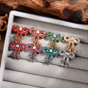 Detailed macro of sparkling rhinestone bow brooches in red, pink, green, and silver colors