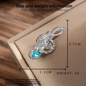 Vintage silver musical note treble clef brooch with sparkling rhinestones and blue gem drop