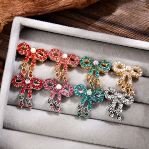 Vintage bowknot brooch with colorful rhinestones and hanging tassels on velvet display