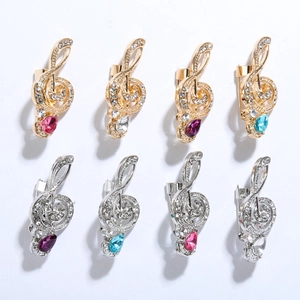 Detail view of treble clef music brooches with sparkling rhinestones and drop gems