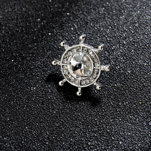 Gros plan de la broche gouvernail argentée ornée de strass sur fond sombre