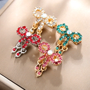Vintage bow brooches with sparkling crystals and teardrop pendants in four colors