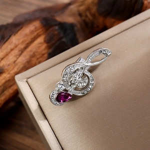 Detail of music note brooch with purple teardrop crystal and sparkling rhinestones