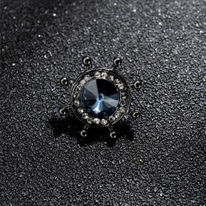 Gros plan sur une broche de gouvernail gris foncé avec une pierre facettée bleu profond