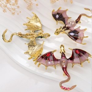 Detailed macro view showing enamel dragon brooches with gold plating and pin closure