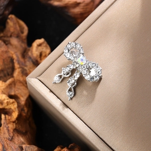 Detail shot of vintage rhinestone bow brooch with shimmering tassels on a jewelry box