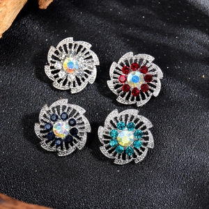 Juego de cuatro broches de flores con pedrería de colores sobre fondo negro