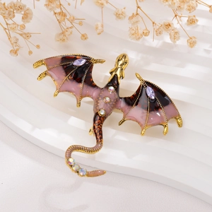 Close-up of golden fantasy dragon brooch with purple enamel and sparkling rhinestones