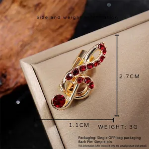 Broche note de musique vintage avec strass rouges et finition dorée élégante
