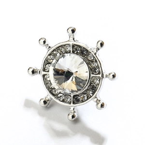 Vue macro d'une broche gouvernail nautique avec strass étincelants sur base argentée
