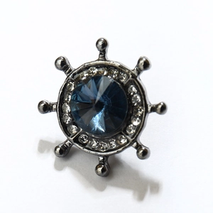 Détail de la broche gouvernail nautique avec pierre bleu foncé et cristaux brillants