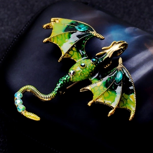 Macro shot of green enamel flying dragon brooch with crystals on black leather base