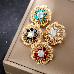 Detalle de cuatro broches florales vintage con diamantes de imitación en dorado