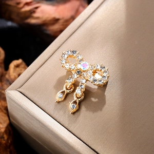 Close-up of golden bow brooch with sparkling rhinestones and iridescent center stone