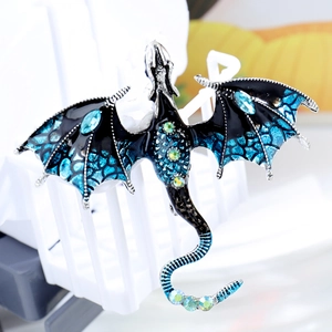 Vintage dragon brooch with black enamel and teal wings featuring sparkling rhinestones