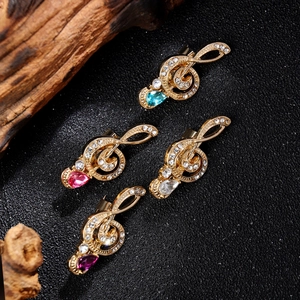 Vintage gold music note brooches with colorful teardrop stones and shimmering crystals
