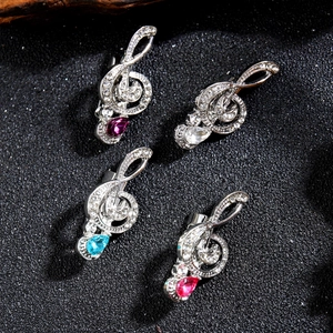 Sparkling silver musical note brooches with crystals and colorful pear-shaped gems