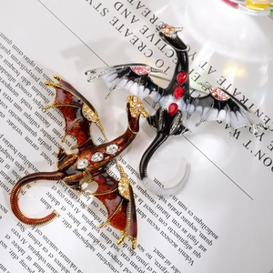 Close-up of vintage dragon brooches with enamel finish and sparkling rhinestone inlay