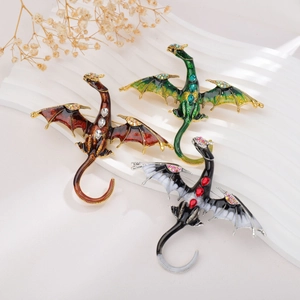 Vintage enamel dragon brooches with rhinestones in green, bronze, and black colors