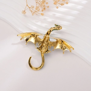 Detail view of the back of a golden dragon brooch featuring a secure safety pin clasp