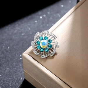 Vista macro de un broche floral con diamantes azules y opale sobre metal fino