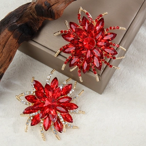 Gros plan d'élégantes broches tournesol en cristal rouge avec placage d'or et strass brillants