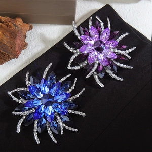 Détail de la broche tournesol avec cristaux marquise bleus et violets sur tissu noir