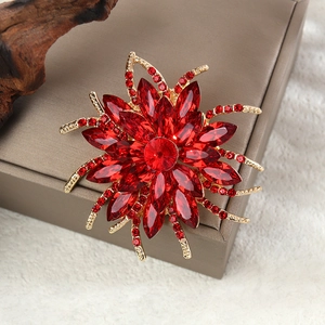 Détail macro d'une grande broche tournesol en cristal rouge avec placage doré fin