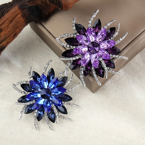 Gros plan sur d'élégantes broches tournesols en cristal de couleur violet et bleu saphir