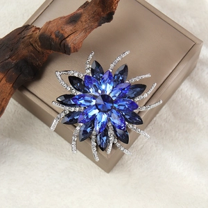 Détail macro d'une broche tournesol avec cristaux bleu foncé sur support en bois