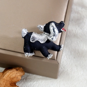 Detailansicht einer Cartoon-Hundebrosche mit mattem Schwarz und Strasshalsband-Detail