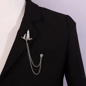 Silver sailing boat brooch with tassels and rhinestones pinned on a black suit lapel