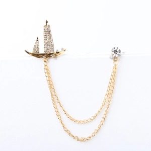 Vintage gold sailboat brooch with rhinestones and double chains on white background