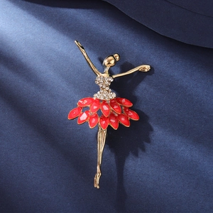Dettaglio di una spilla ballerina elegante placcata oro con smalto rosso e cristalli
