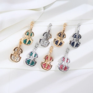 Macro detail of violin brooches in gold and silver with colorful crystal inlay