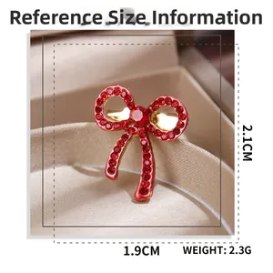 Detailed view of a red bow brooch with rhinestones and size dimensions in centimeters