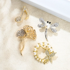 Détails de quatre broches en cristal aux motifs animaux et floraux sur pierre