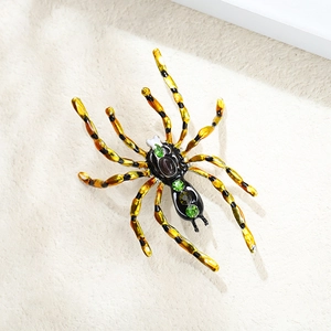 Gros plan détaillé d'une broche araignée avec émail jaune et pierres précieuses vertes