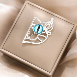 Détail de la broche animale argentée avec pierre œil de chat bleue en boîte cadeau